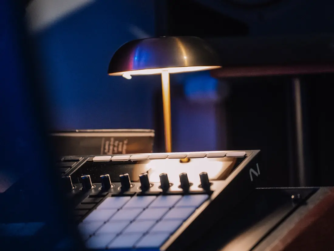 Maschine Studio under a brass desk lamp